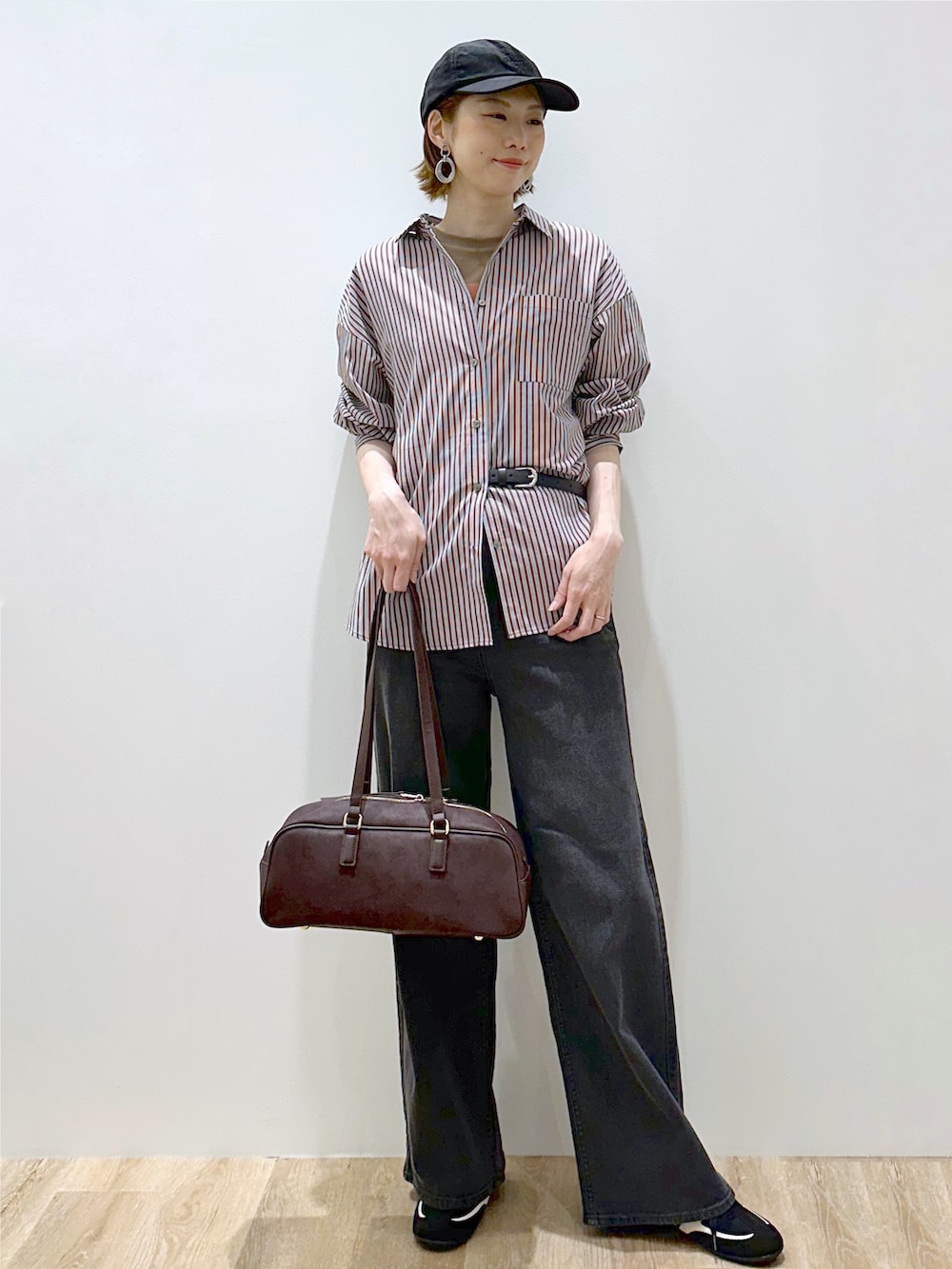 ブラウン系のシャツ/ブラウス、ブラウン系のTシャツ/カットソー、ブラック系のデニムパンツを着用したレディースの秋コーディネートの7枚目の写真