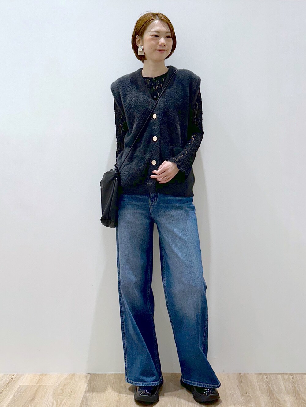 グレー系のニット/セーター、ブラック系のカーディガン/ボレロ、ブルー系のデニムパンツを着用したレディースの秋コーディネートの6枚目の写真