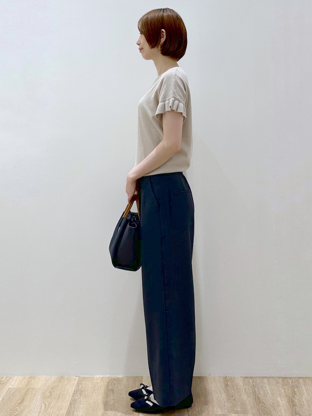 ベージュ系のニット/セーター、ブルー系のその他パンツ、ブルー系のトートバッグを着用したレディースの夏コーディネートの5枚目の写真