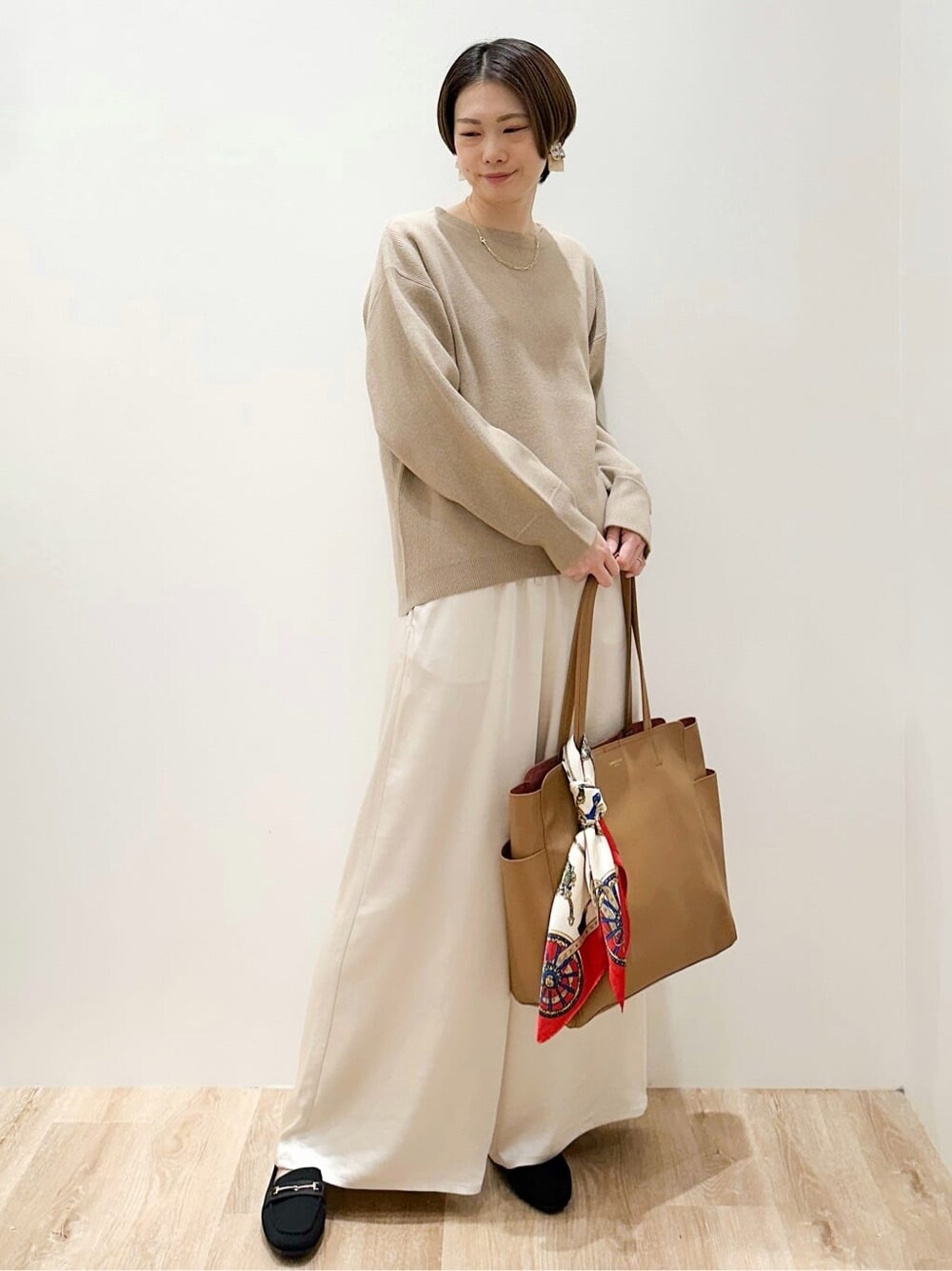 ベージュ系のニット/セーター、ホワイト系のその他パンツ、ベージュ系のトートバッグを着用したレディースの冬コーディネートの6枚目の写真