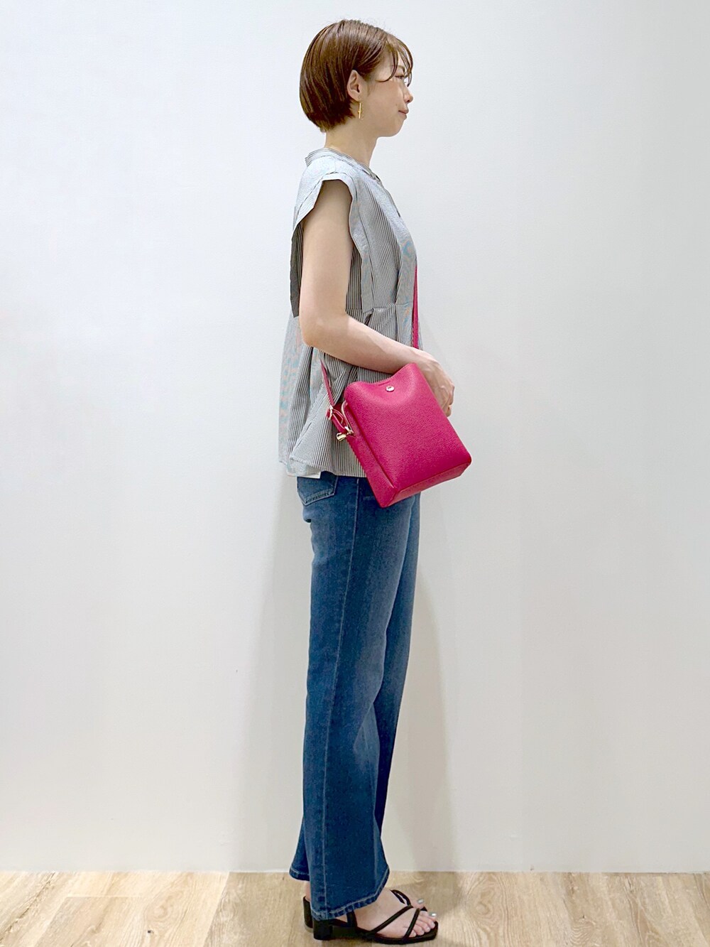 ホワイト系のシャツ/ブラウス、ブルー系のデニムパンツ、ピンク系のショルダーバッグを着用したレディースの夏コーディネートの3枚目の写真