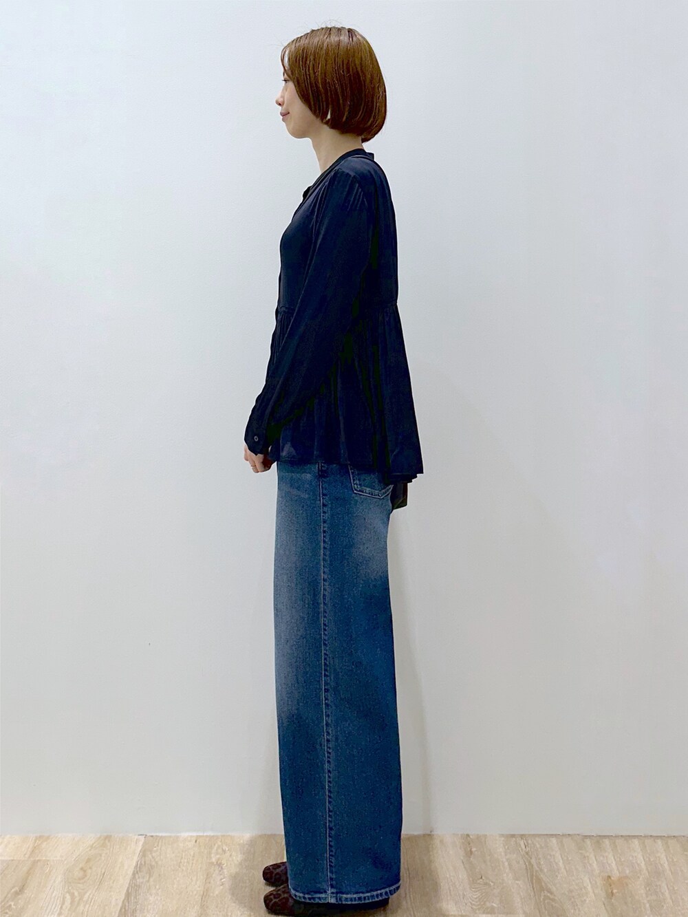ブルー系のシャツ/ブラウス、ブルー系のデニムパンツ、ブラック系のショルダーバッグを着用したレディースの秋コーディネートの6枚目の写真