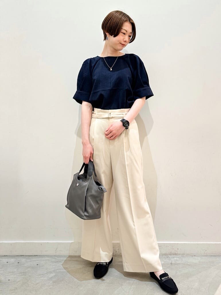 ブルー系のシャツ/ブラウス、ベージュ系のその他パンツ、グレー系のトートバッグを着用したレディースの春コーディネートの2枚目の写真
