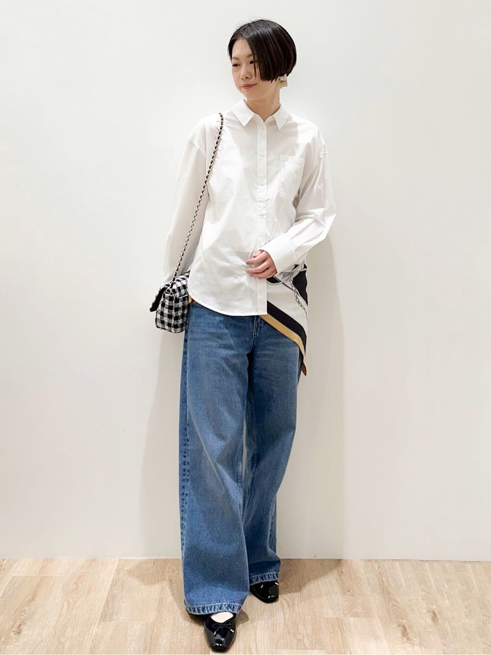 ブルー系のデニムパンツ、ブラック系のパンプス、ホワイト系のシャツ/ブラウスを着用したレディースの春コーディネートの6枚目の写真