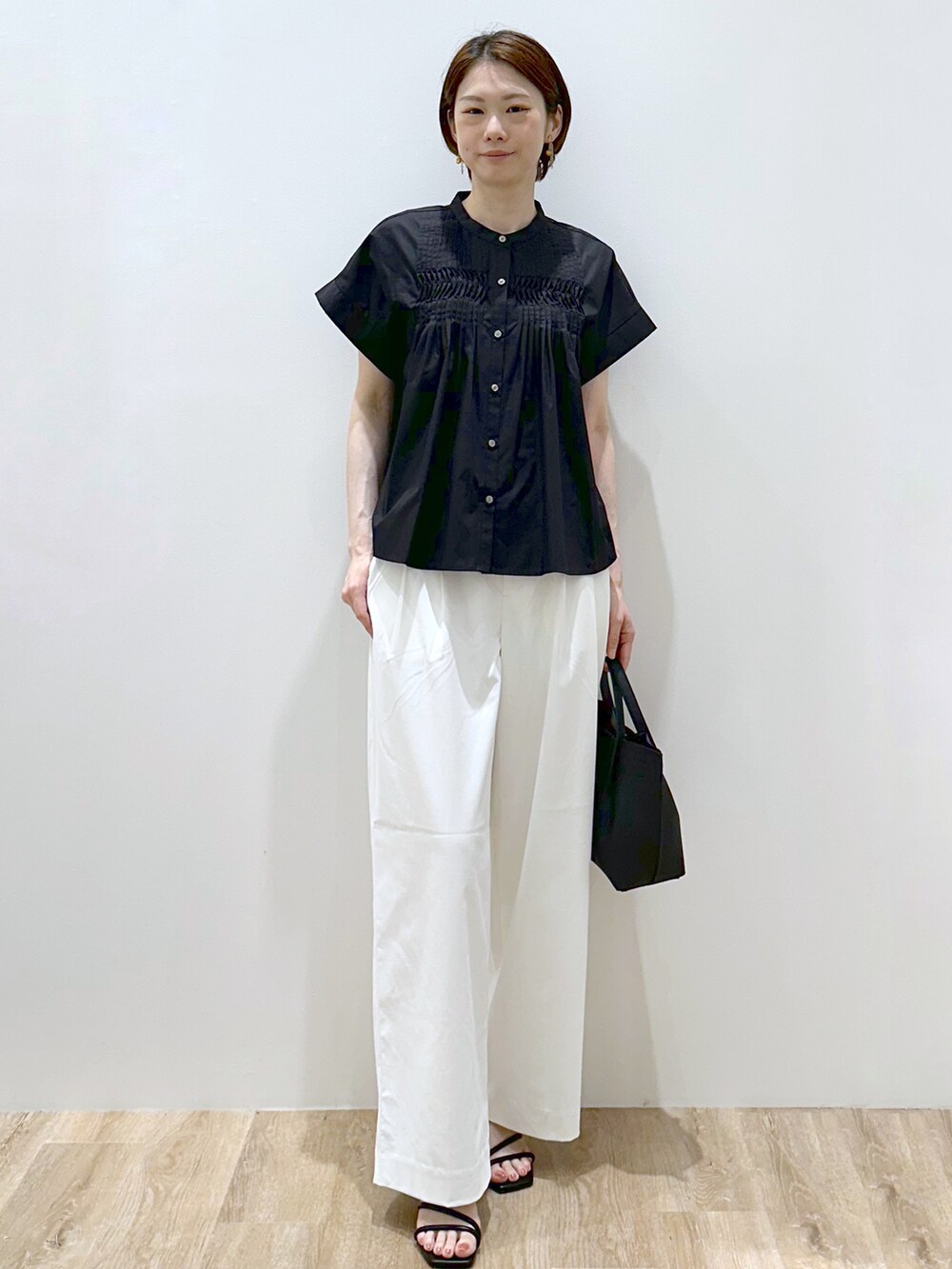 ブラック系のシャツ/ブラウス、ホワイト系のその他パンツ、ブラック系のトートバッグを着用したレディースの夏コーディネートの6枚目の写真