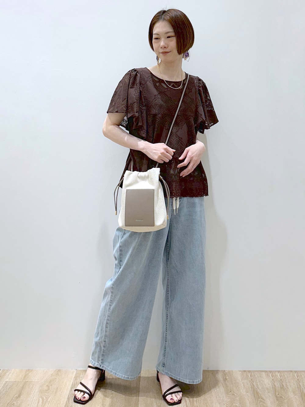 ブラウン系のシャツ/ブラウス、ブルー系のデニムパンツ、ブラック系のサンダルを着用したレディースの春コーディネートの5枚目の写真