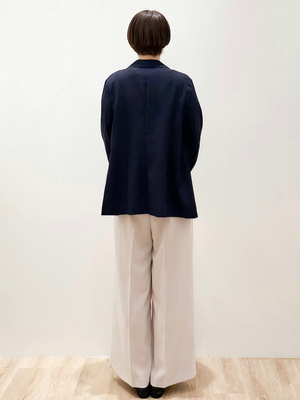 ブラック系のパンプス、ベージュ系のトートバッグ、ブルー系のテーラードジャケットを着用したレディースの春コーディネートの3枚目の写真