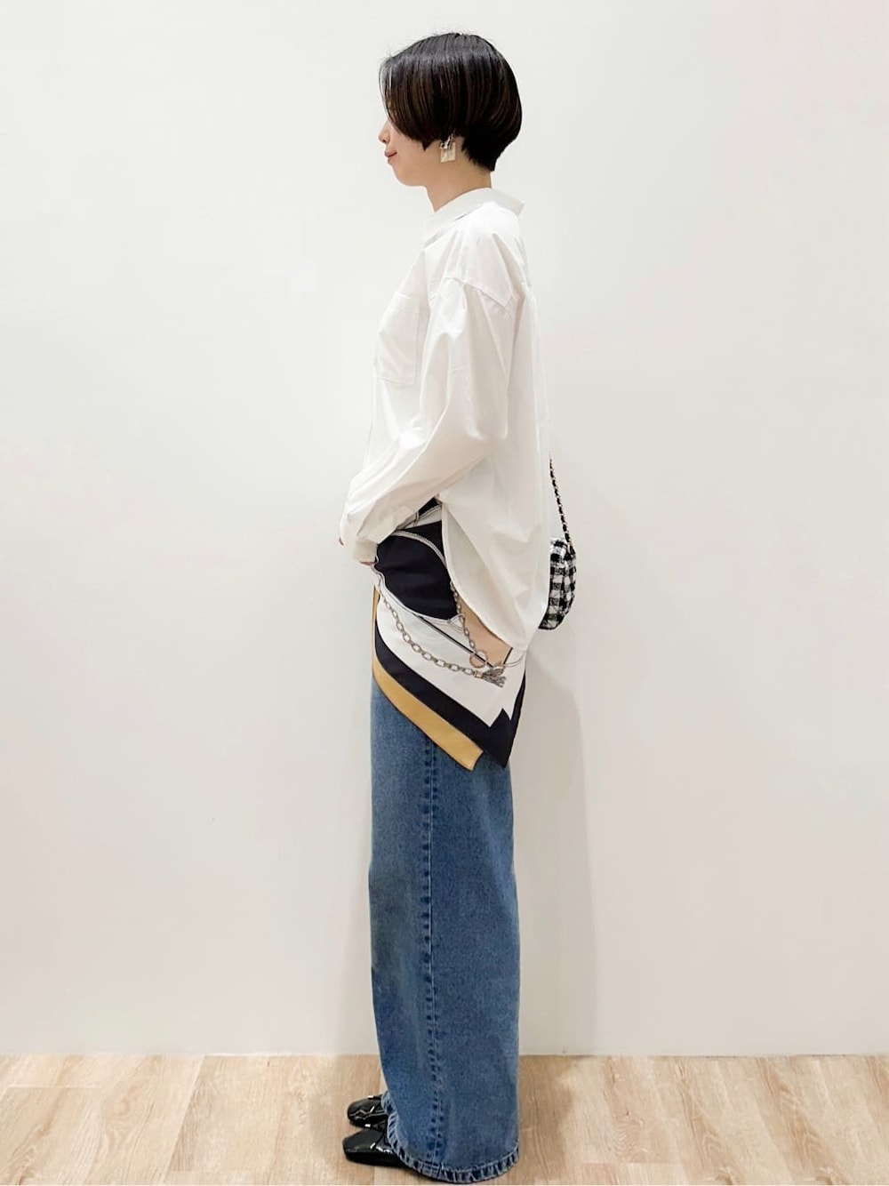 ブルー系のデニムパンツ、ブラック系のパンプス、ホワイト系のシャツ/ブラウスを着用したレディースの春コーディネートの3枚目の写真