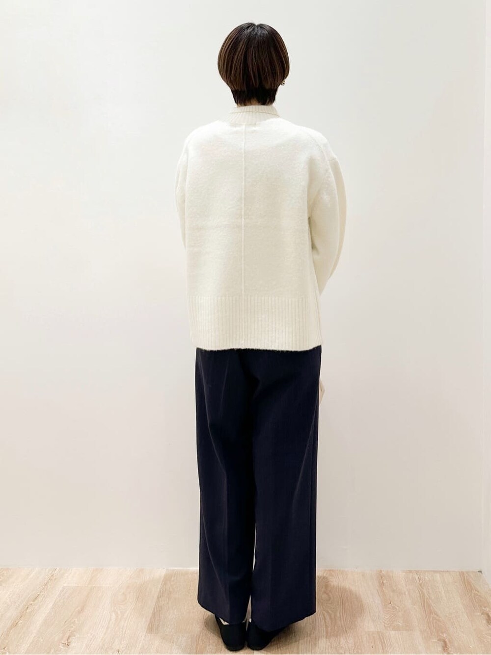 ホワイト系のニット/セーター、ブラック系のその他パンツ、ベージュ系のボストンバッグを着用したレディースの冬コーディネートの5枚目の写真