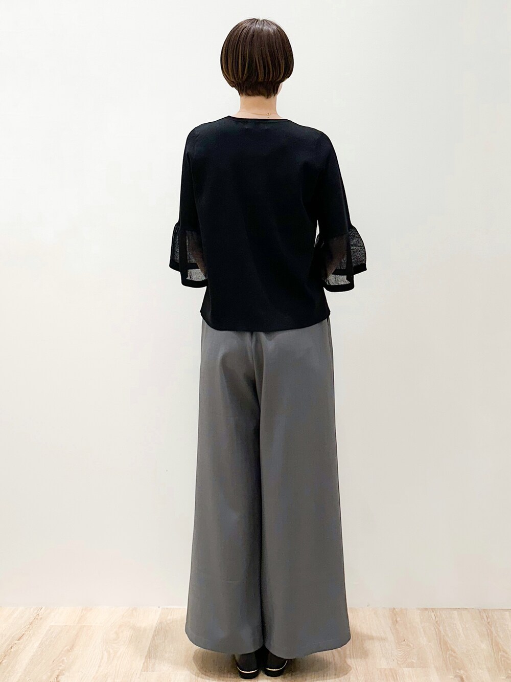 ブラック系のパンプス、グレー系のその他パンツ、ブラック系のショルダーバッグを着用したレディースの春コーディネートの3枚目の写真