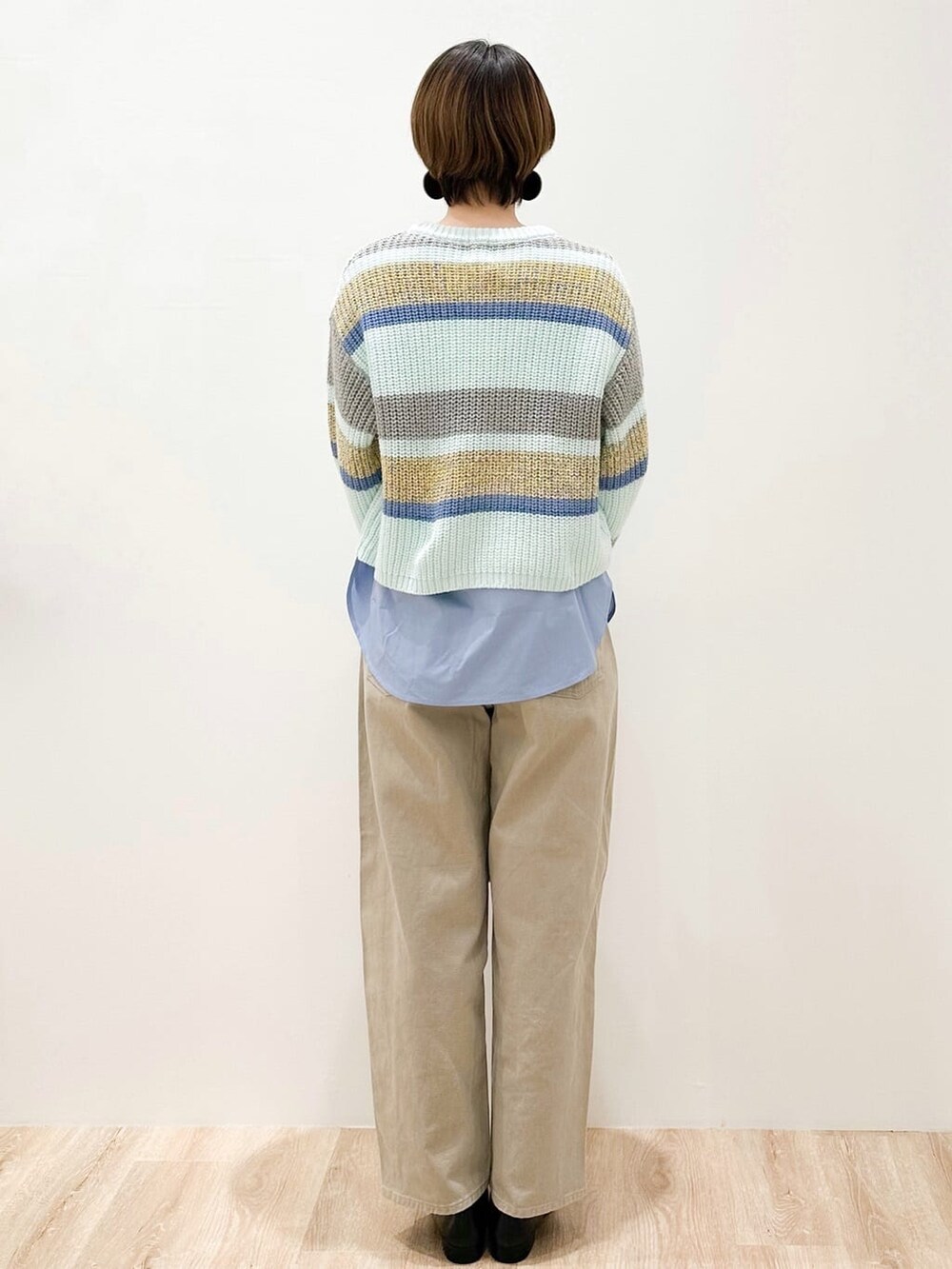 グリーン系のニット/セーター、ブルー系のTシャツ/カットソー、ベージュ系のデニムパンツを着用したレディースの冬コーディネートの3枚目の写真