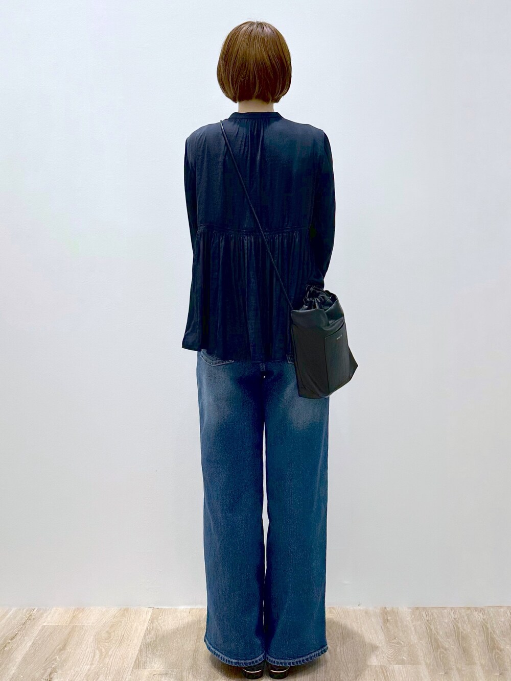 ブルー系のシャツ/ブラウス、ブルー系のデニムパンツ、ブラック系のショルダーバッグを着用したレディースの秋コーディネートの5枚目の写真
