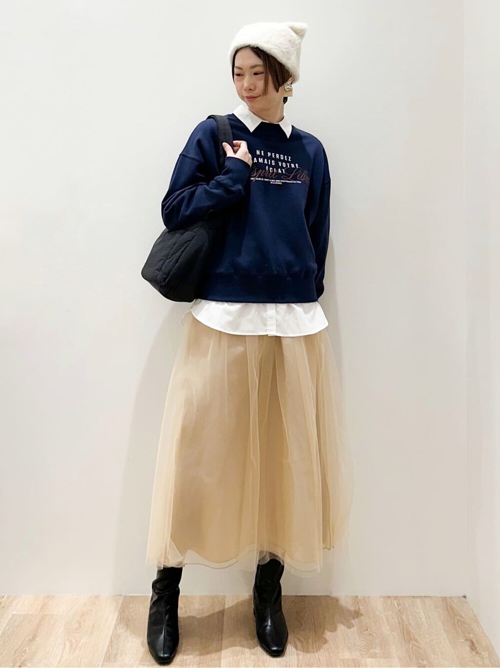 ブルー系のスウェット、ホワイト系のシャツ/ブラウス、ベージュ系のスカートを着用したレディースの冬コーディネートの6枚目の写真