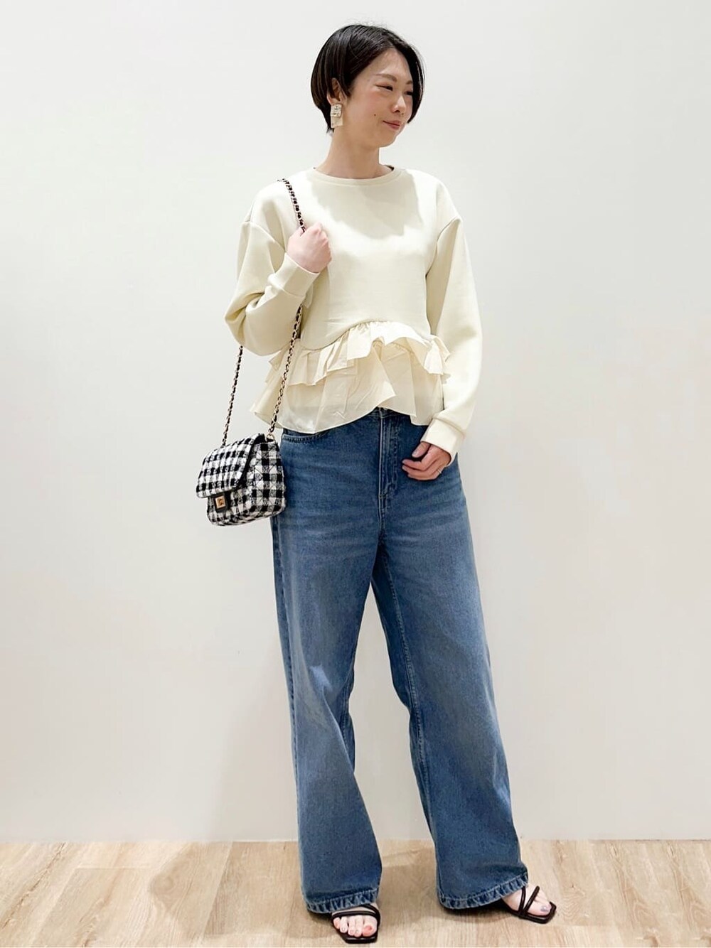 イエロー系のTシャツ/カットソー、ブルー系のデニムパンツ、ブラック系のショルダーバッグを着用したレディースの春コーディネートの2枚目の写真