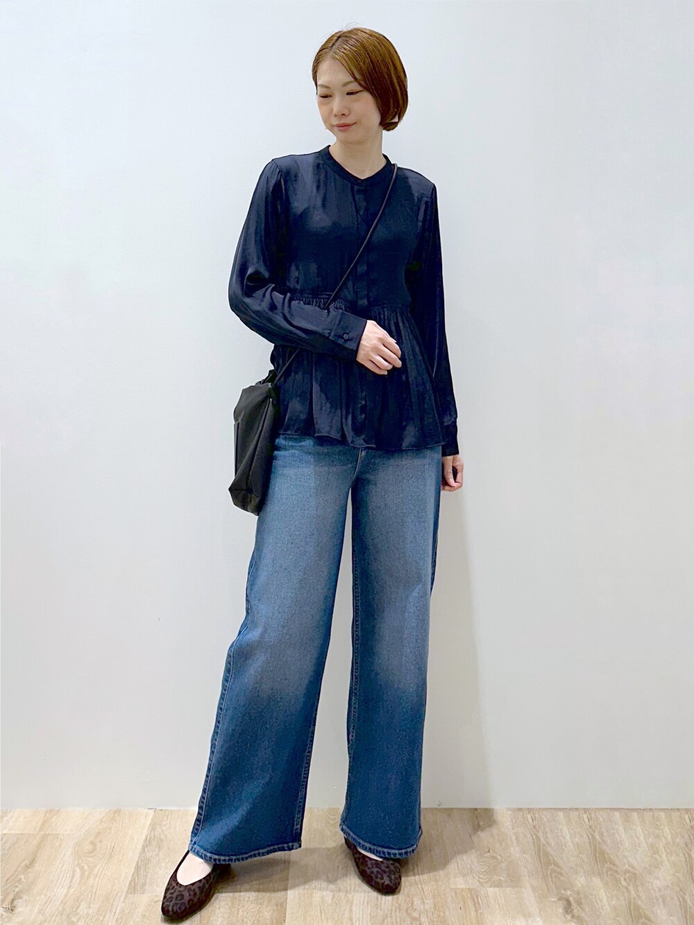 ブルー系のシャツ/ブラウス、ブルー系のデニムパンツ、ブラック系のショルダーバッグを着用したレディースの秋コーディネートの2枚目の写真