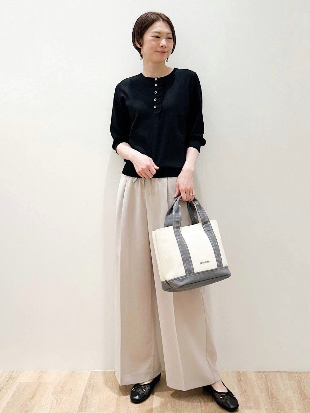 ブラック系のパンプス、ベージュ系のその他パンツ、グレー系のトートバッグを着用したレディースの春コーディネートの5枚目の写真