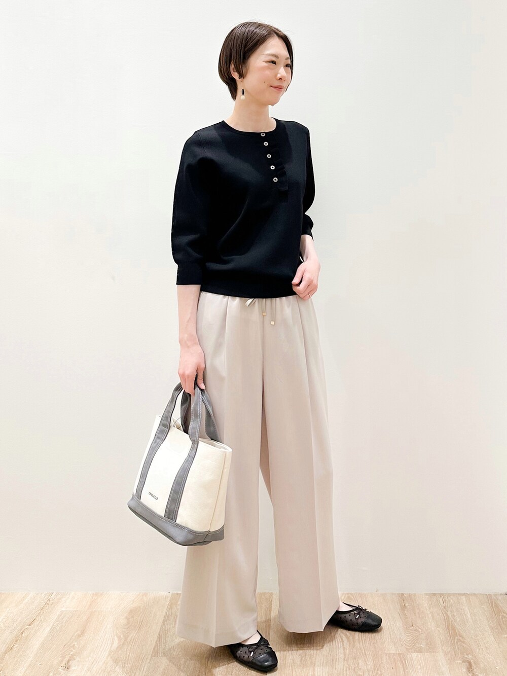 ブラック系のパンプス、ベージュ系のその他パンツ、グレー系のトートバッグを着用したレディースの春コーディネートの2枚目の写真
