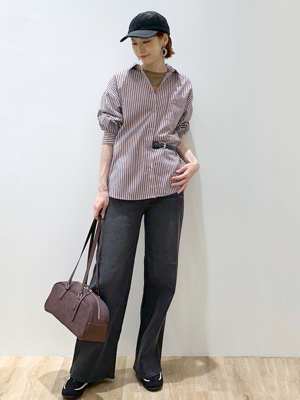 ブラウン系のシャツ/ブラウス、ブラウン系のTシャツ/カットソー、ブラック系のデニムパンツを着用したレディースの秋コーディネートの2枚目の写真