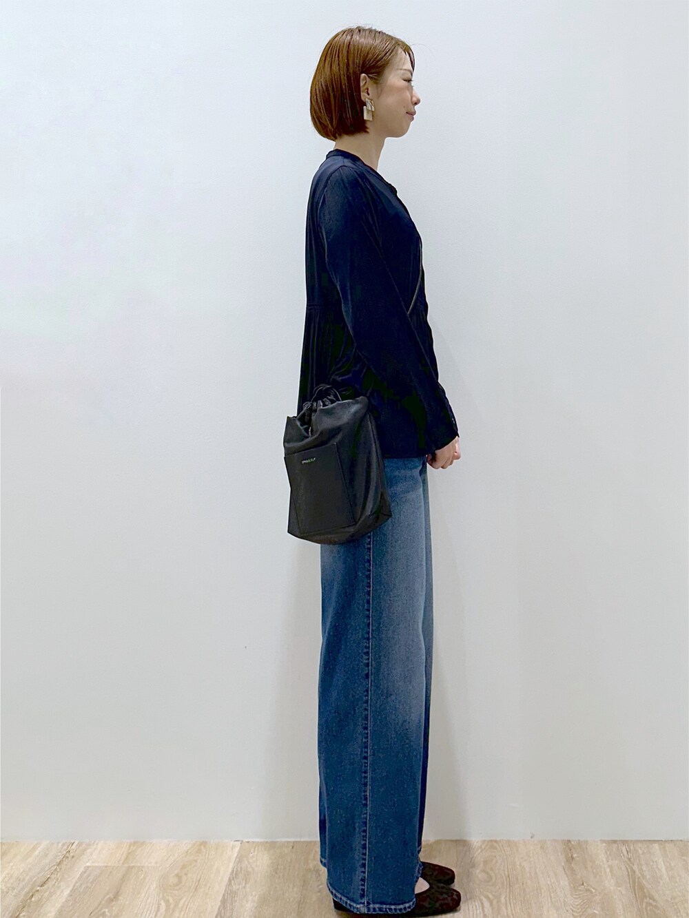 ブルー系のシャツ/ブラウス、ブルー系のデニムパンツ、ブラック系のショルダーバッグを着用したレディースの秋コーディネートの4枚目の写真