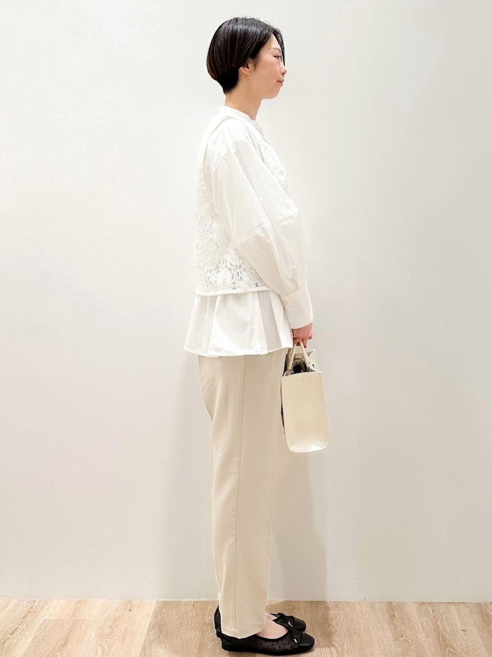 ブラック系のパンプス、ベージュ系のその他パンツ、ホワイト系のトートバッグを着用したレディースの春コーディネートの3枚目の写真