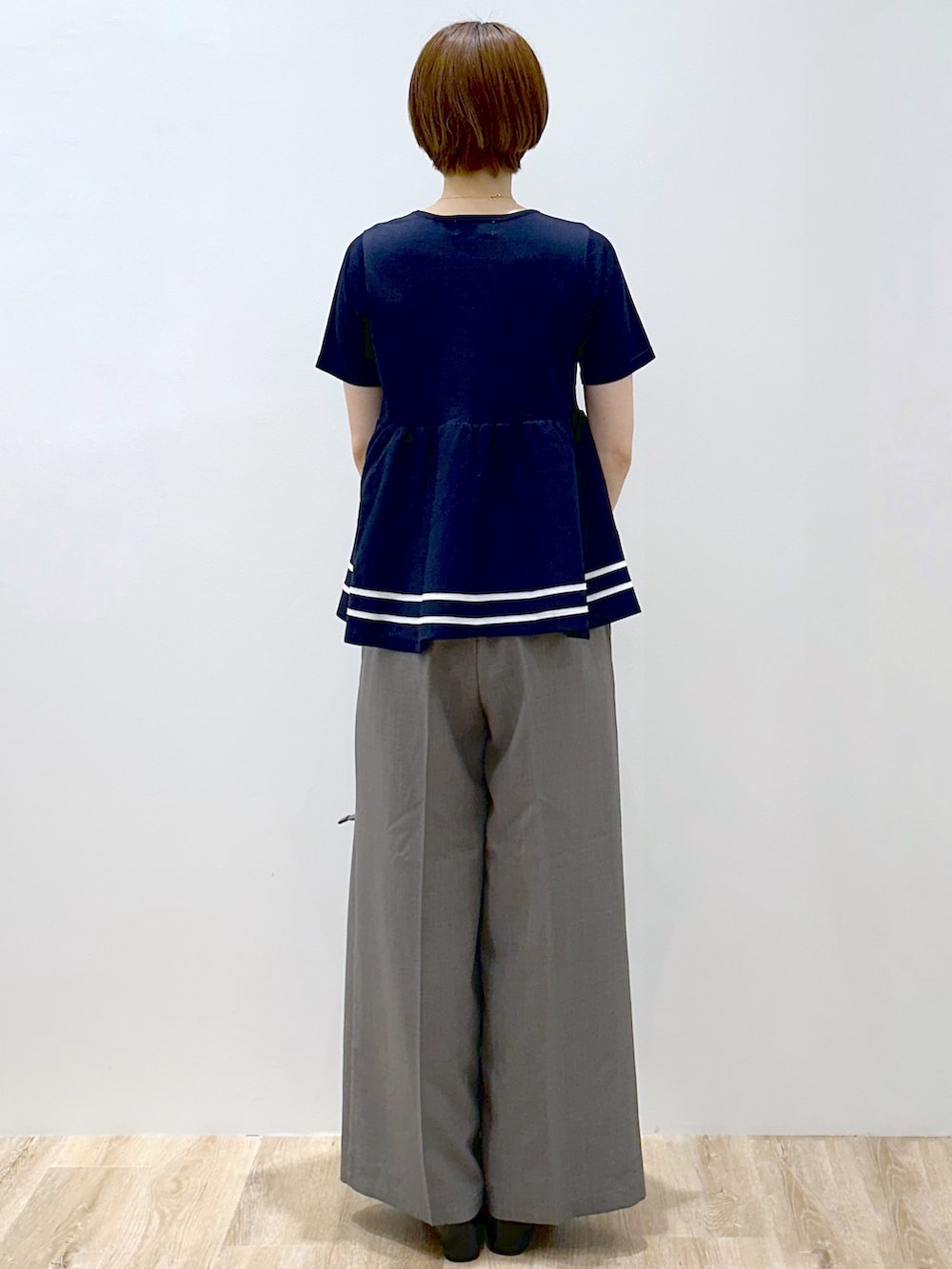 ブルー系のニット/セーター、グレー系のその他パンツ、グレー系のトートバッグを着用したレディースの夏コーディネートの4枚目の写真