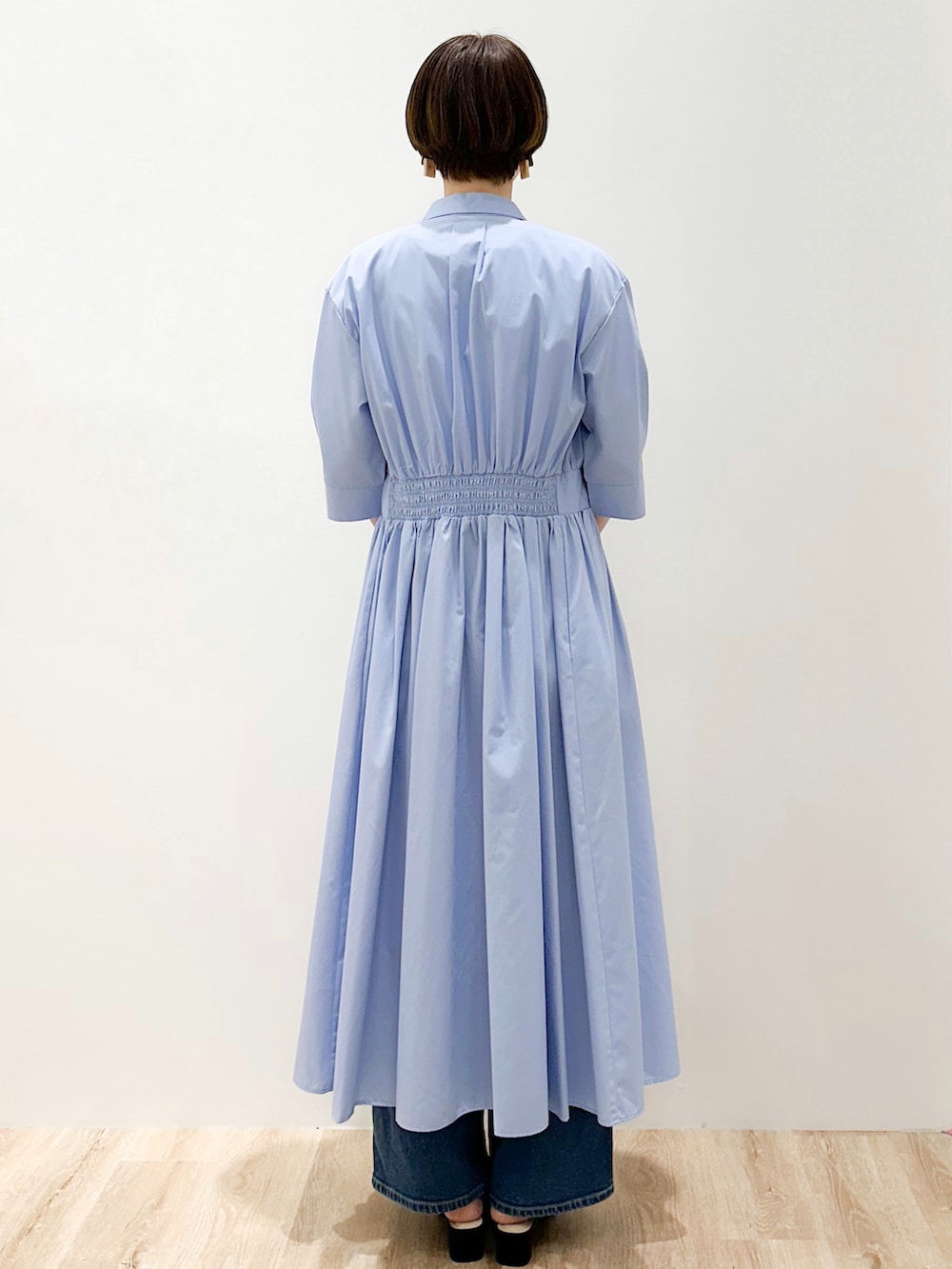 ブルー系のデニムパンツ、ブルー系のワンピース、ホワイト系のトートバッグを着用したレディースの春コーディネートの4枚目の写真