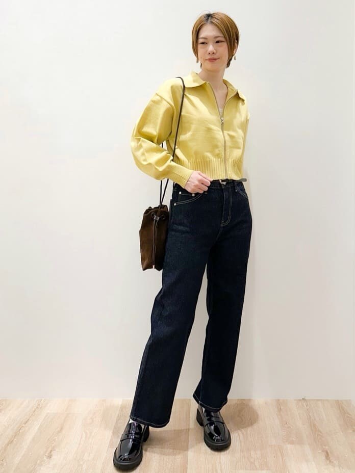 イエロー系のカーディガン/ボレロ、ブルー系のデニムパンツ、ブラウン系のショルダーバッグを着用したレディースの秋コーディネートの3枚目の写真