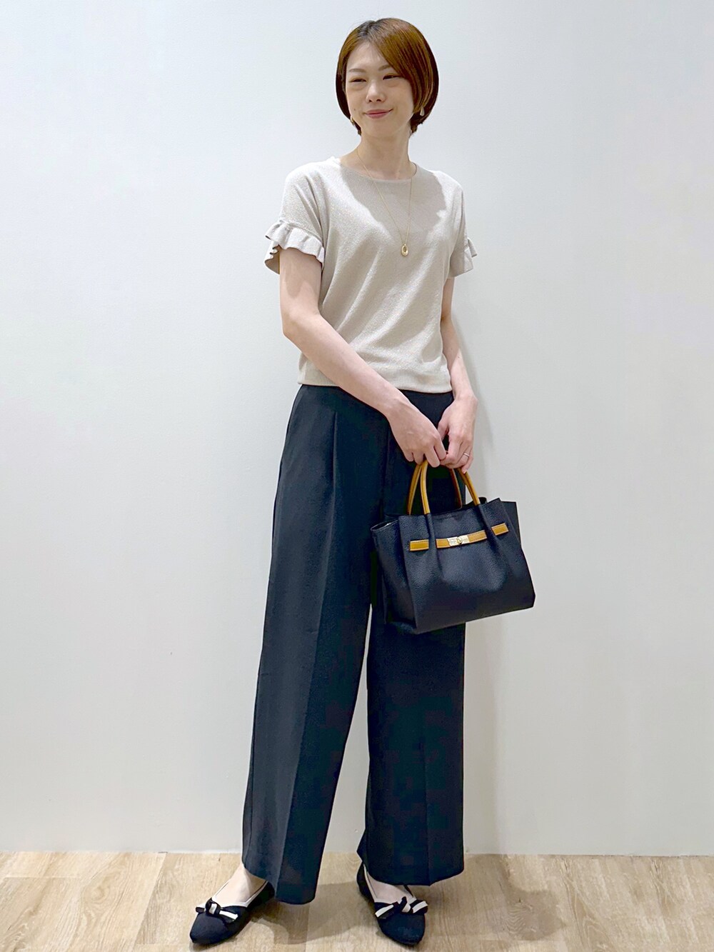 ベージュ系のニット/セーター、ブルー系のその他パンツ、ブルー系のトートバッグを着用したレディースの夏コーディネートの6枚目の写真