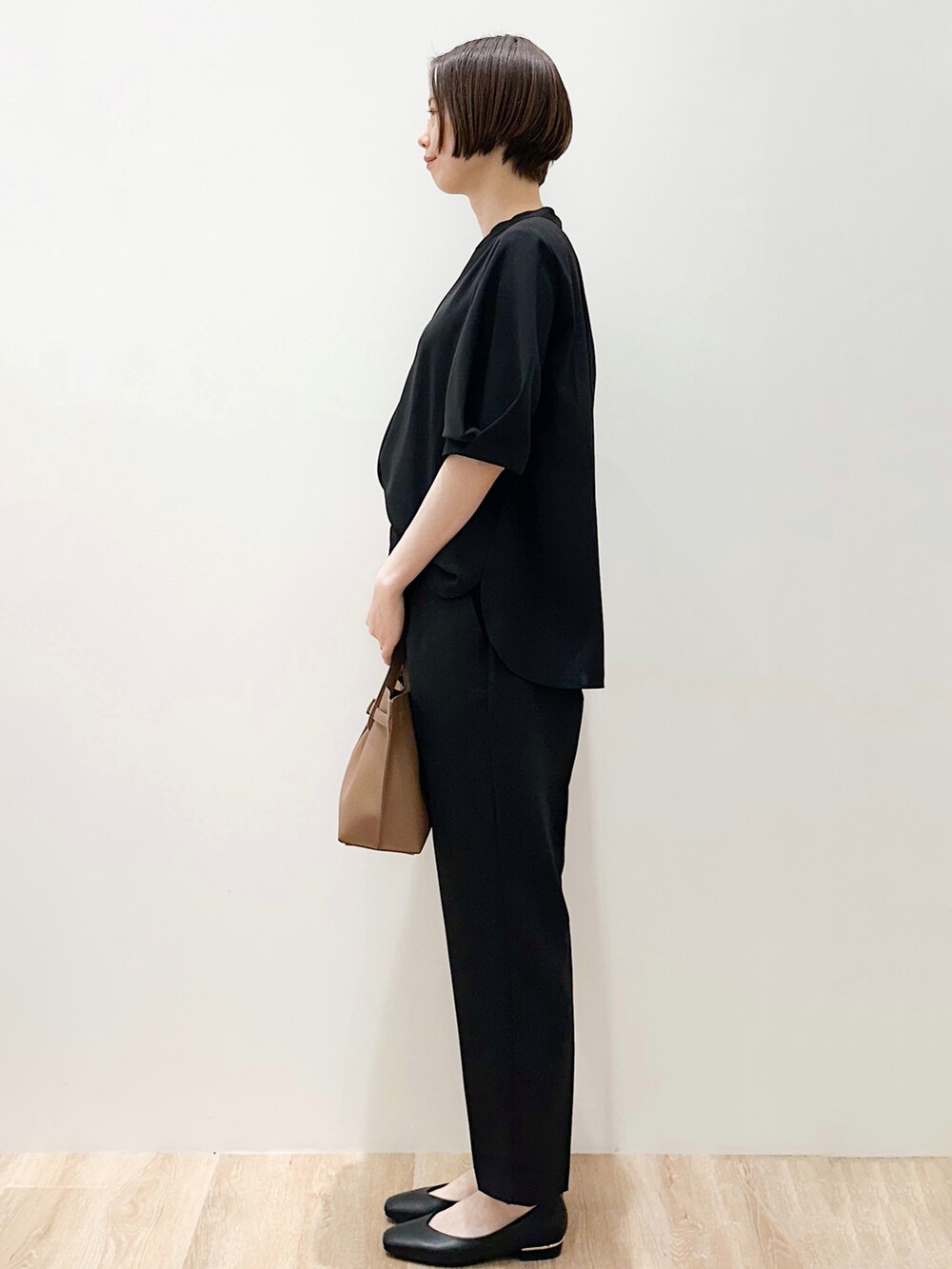 ブラック系のパンプス、ブラック系のシャツ/ブラウス、ブラック系のその他パンツを着用したレディースの春コーディネートの2枚目の写真