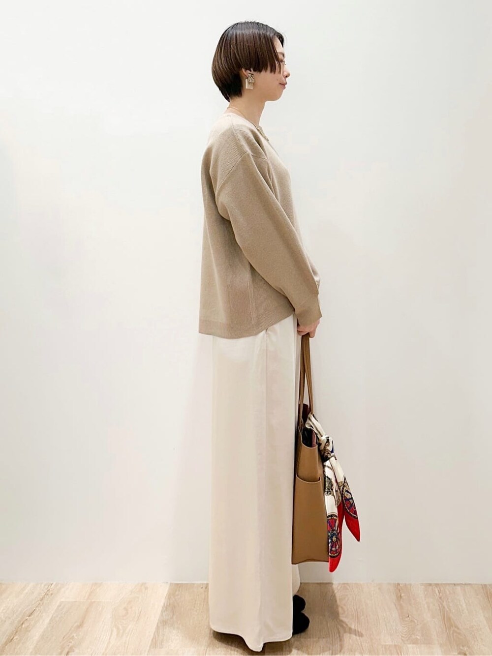 ベージュ系のニット/セーター、ホワイト系のその他パンツ、ベージュ系のトートバッグを着用したレディースの冬コーディネートの5枚目の写真