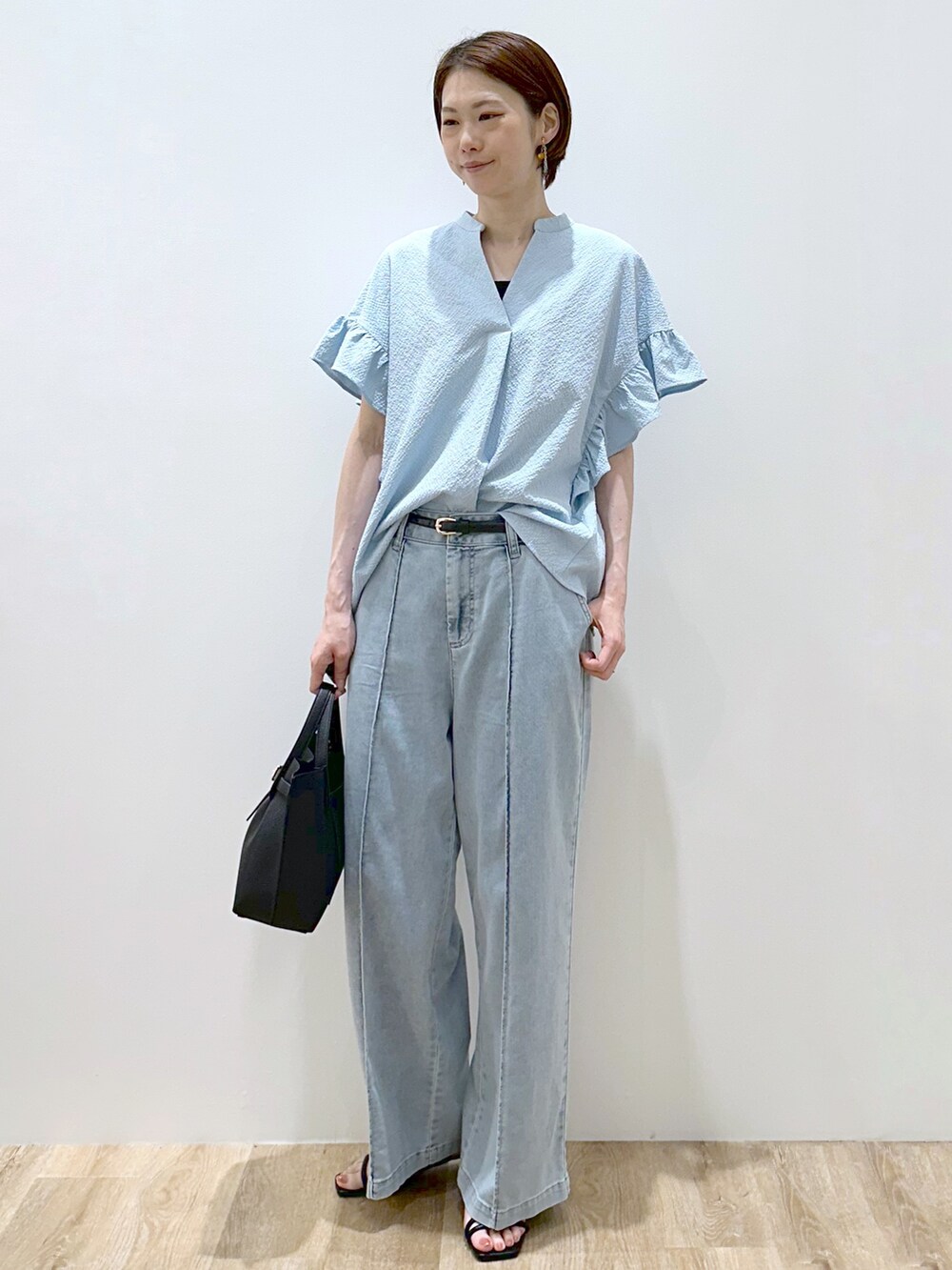 ブルー系のシャツ/ブラウス、ブラック系のタンクトップ、ブルー系のデニムパンツを着用したレディースの夏コーディネートの2枚目の写真