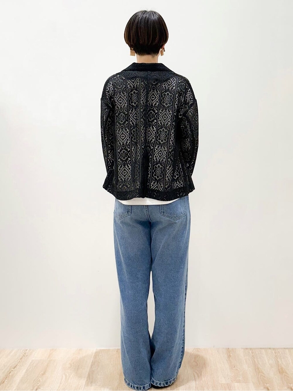 ブルー系のデニムパンツ、ブラック系のパンプス、ベージュ系のトートバッグを着用したレディースの春コーディネートの3枚目の写真