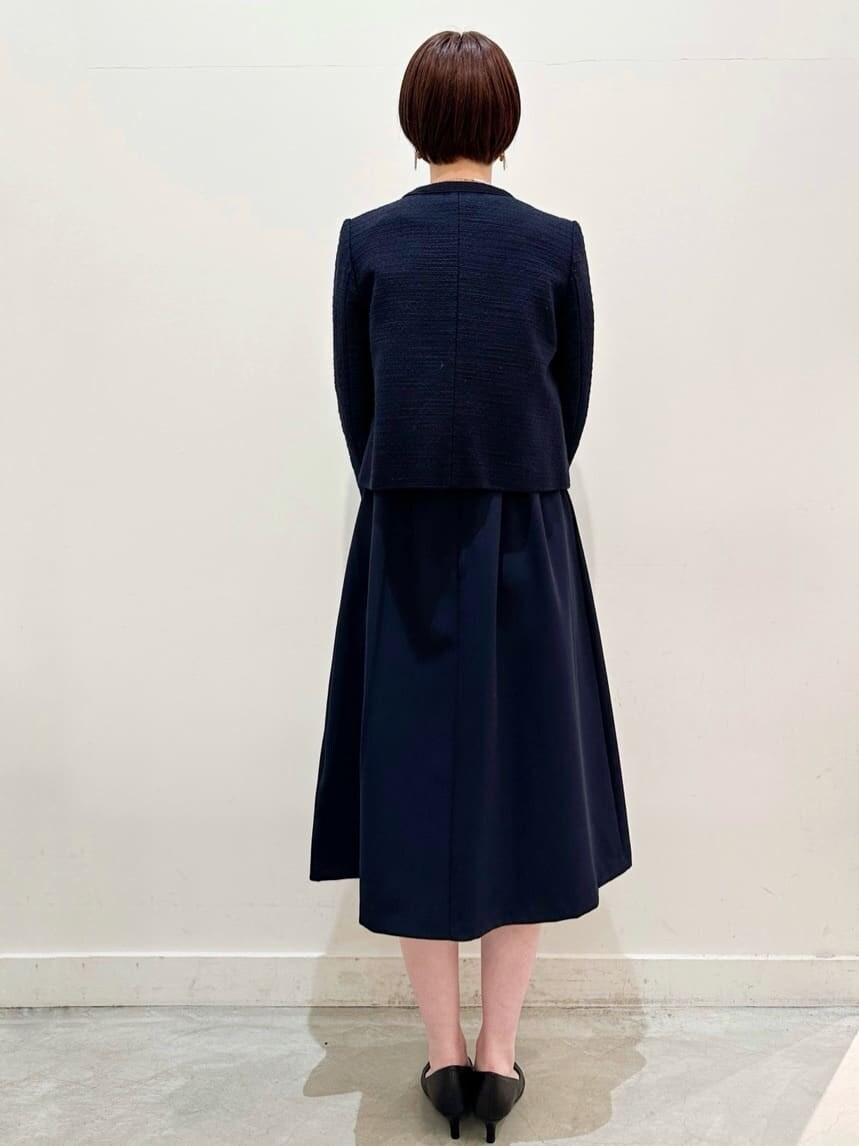 ブルー系のノーカラージャケット、ブルー系のワンピース、ブラック系のトートバッグを着用したレディースの冬コーディネートの3枚目の写真