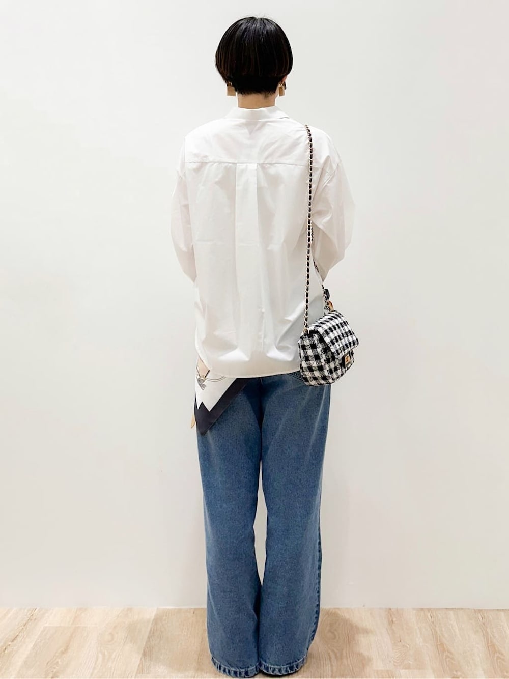 ブルー系のデニムパンツ、ブラック系のパンプス、ホワイト系のシャツ/ブラウスを着用したレディースの春コーディネートの4枚目の写真