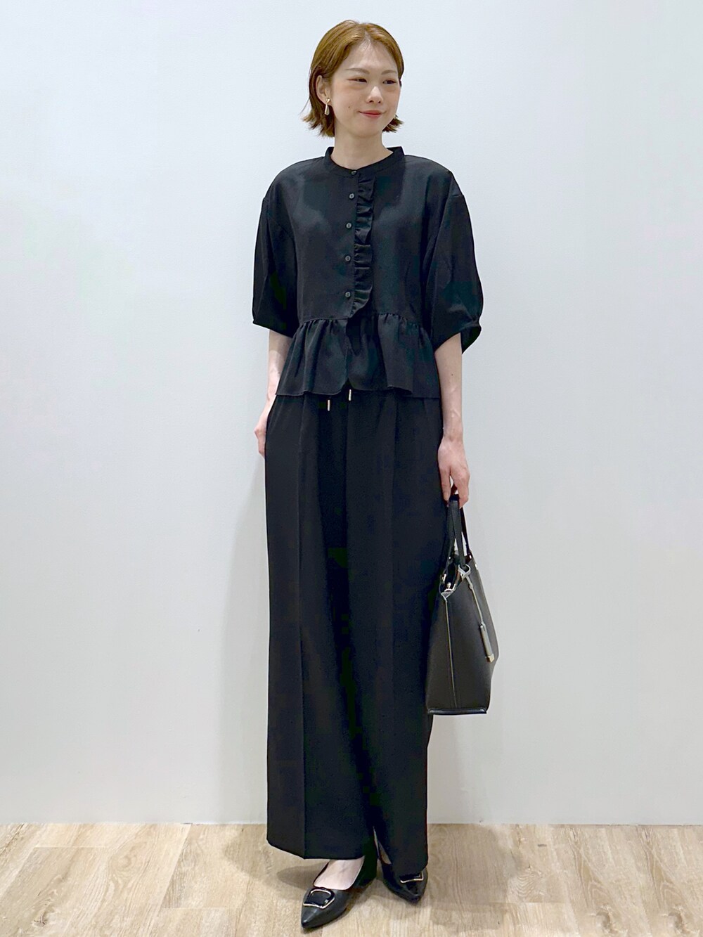 ブラック系のシャツ/ブラウス、ブラック系のその他パンツ、ブラック系のトートバッグを着用したレディースの秋コーディネートの2枚目の写真