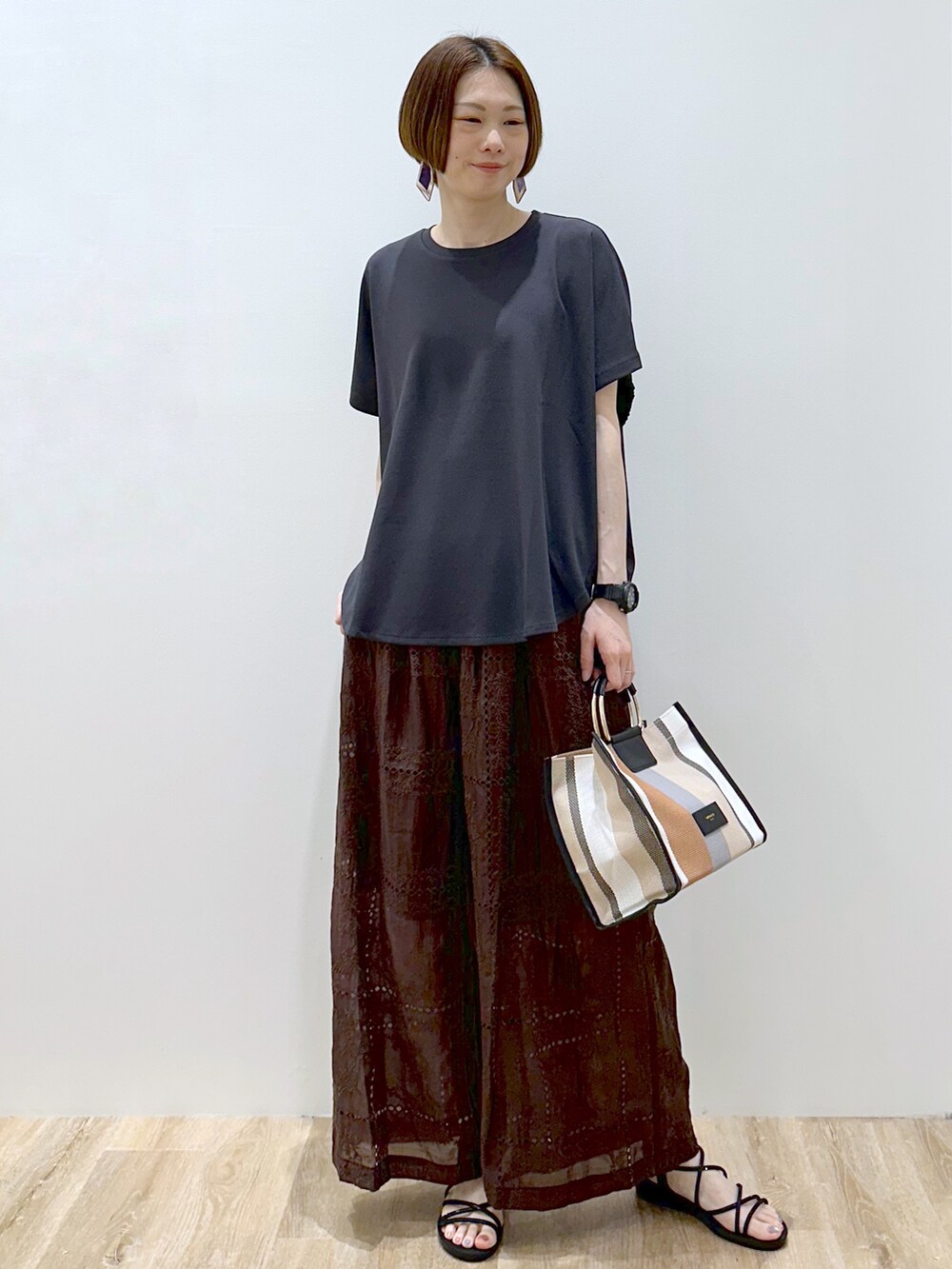 グレー系のTシャツ/カットソー、ブラウン系のその他パンツ、ブラック系のトートバッグを着用したレディースの春コーディネートの4枚目の写真