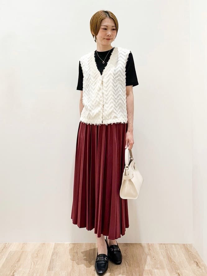 ホワイト系のベスト、ブラック系のTシャツ/カットソー、レッド系のスカートを着用したレディースの夏コーディネートの4枚目の写真