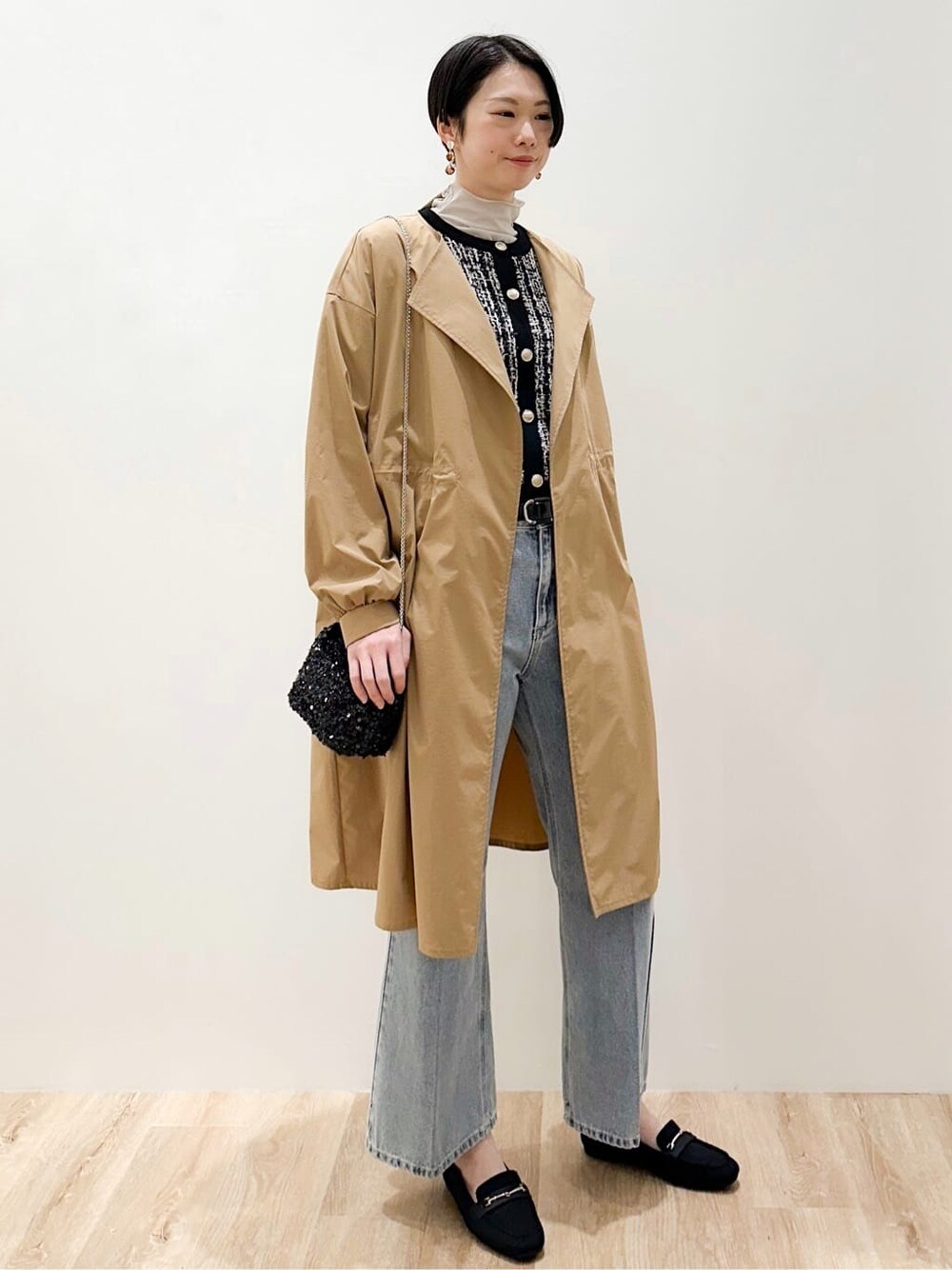 ブラック系のカーディガン/ボレロ、グレー系のTシャツ/カットソー、ブルー系のデニムパンツを着用したレディースの冬コーディネートの2枚目の写真