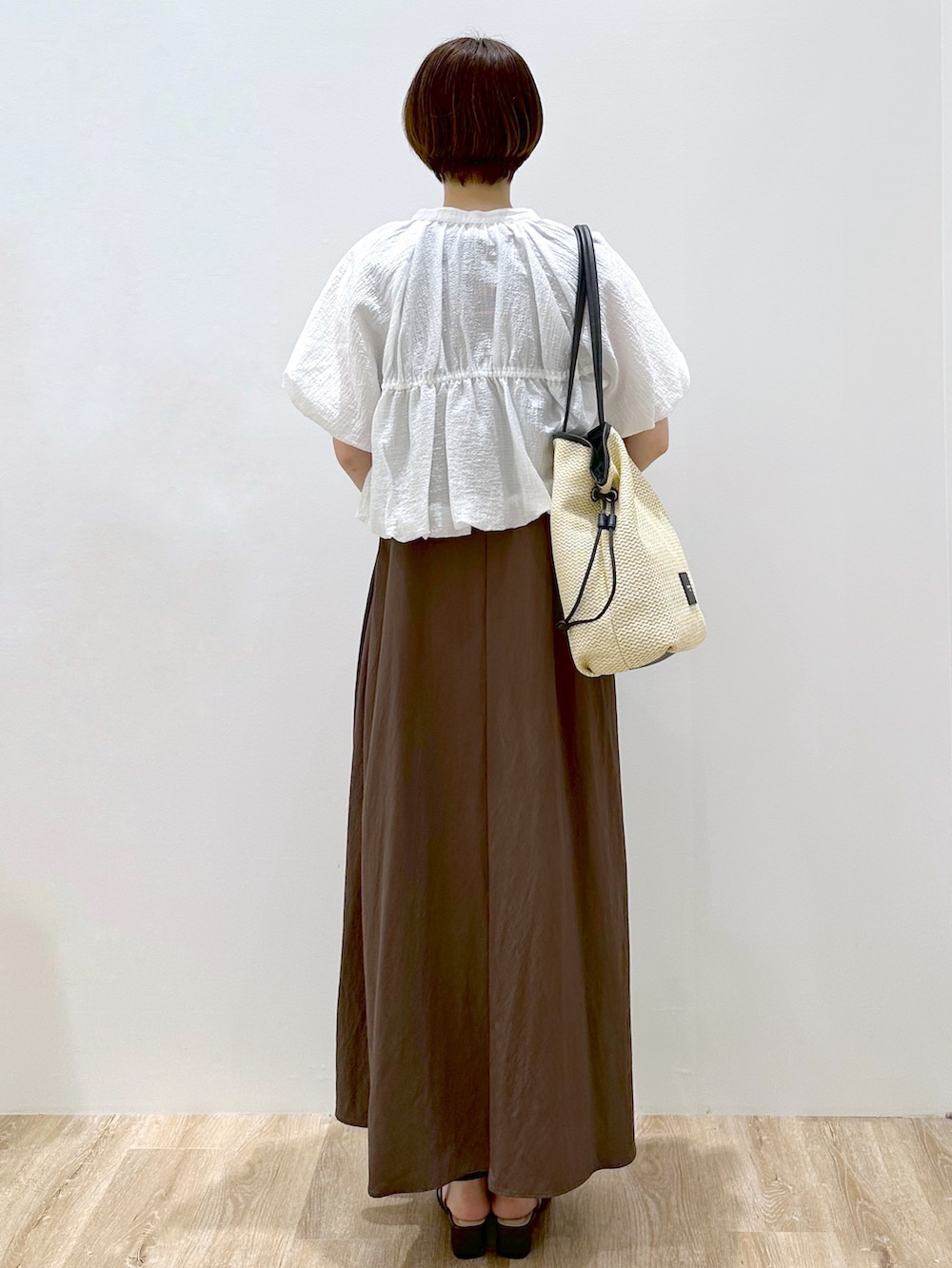 ブルー系のTシャツ/カットソー、ブラウン系のワンピース、ホワイト系のトートバッグを着用したレディースの春コーディネートの3枚目の写真
