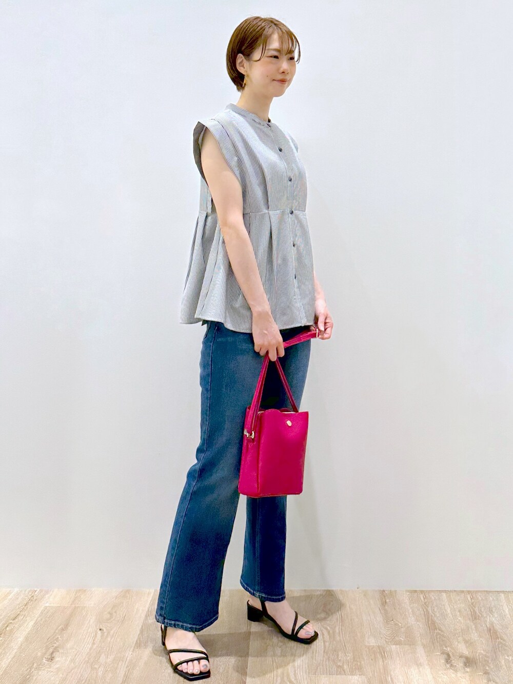 ホワイト系のシャツ/ブラウス、ブルー系のデニムパンツ、ピンク系のショルダーバッグを着用したレディースの夏コーディネートの5枚目の写真