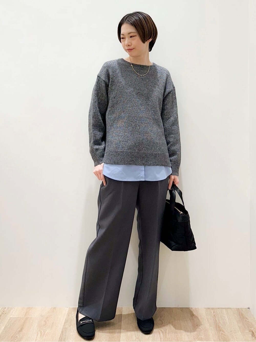 ブラック系のダウンジャケット/コート、グレー系のニット/セーター、ブルー系のTシャツ/カットソーを着用したレディースの冬コーディネートの7枚目の写真