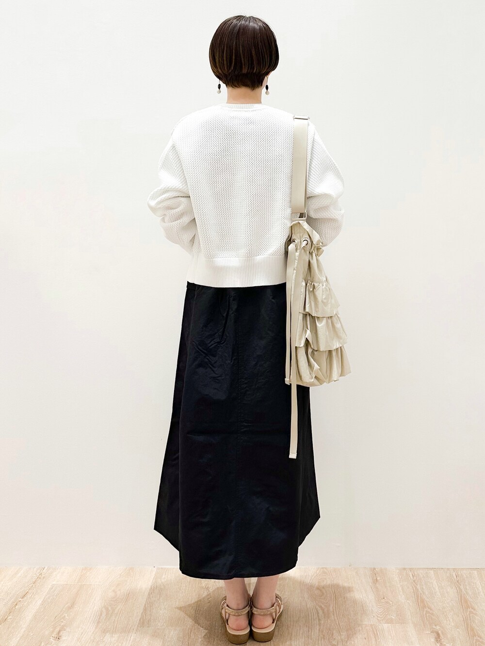 ホワイト系のカーディガン/ボレロ、ブルー系のTシャツ/カットソー、ブラック系のワンピースを着用したレディースの春コーディネートの3枚目の写真