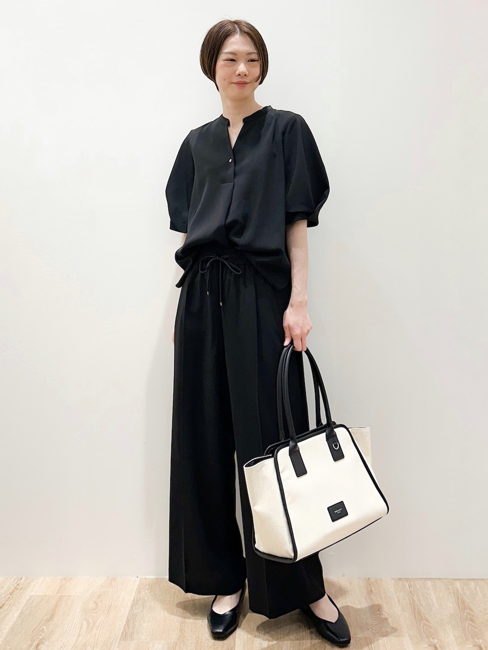 ブラック系のパンプス、ブラック系のシャツ/ブラウス、ブラック系のその他パンツを着用したレディースの春コーディネートの2枚目の写真