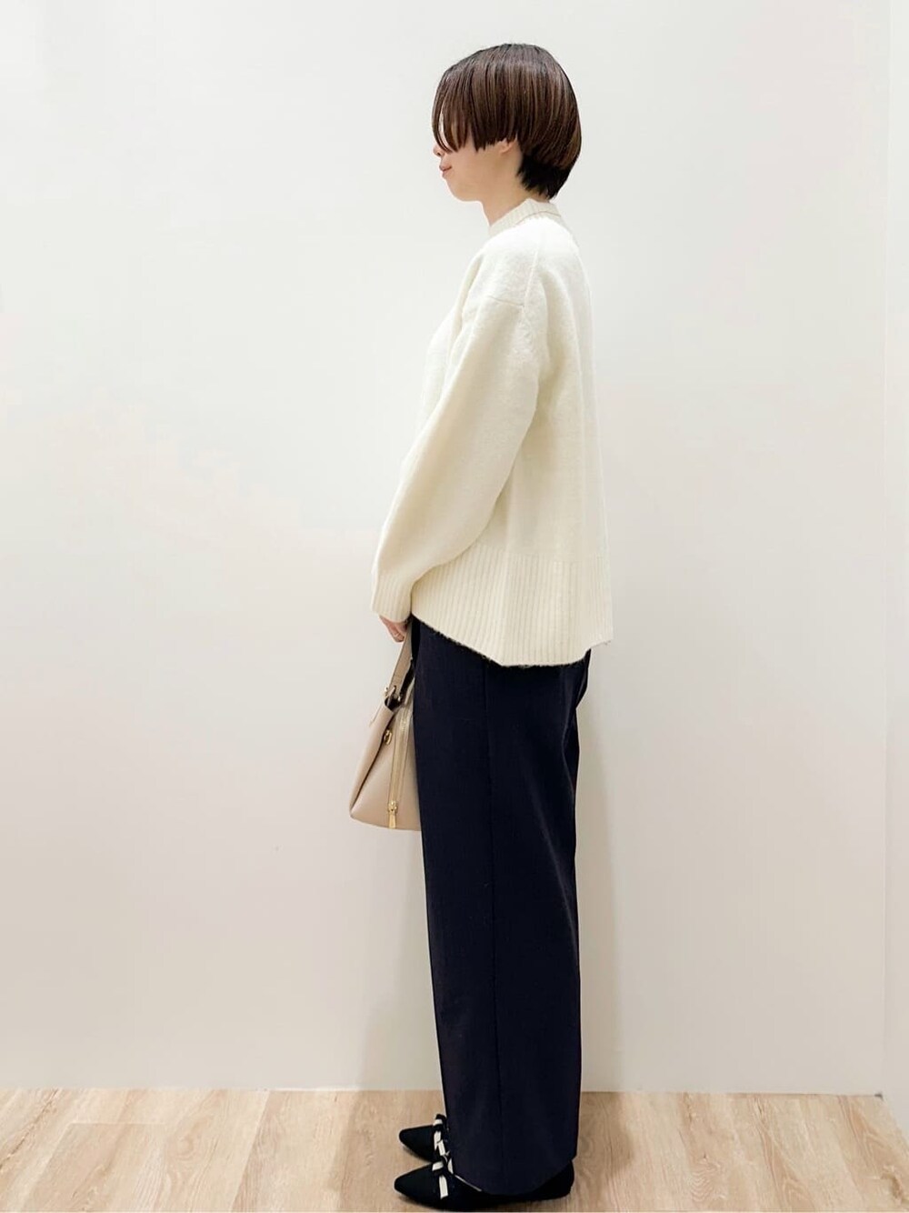 ホワイト系のニット/セーター、ブラック系のその他パンツ、ベージュ系のボストンバッグを着用したレディースの冬コーディネートの4枚目の写真