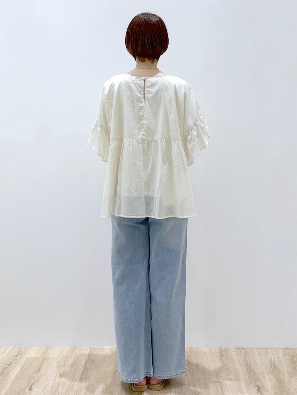 ホワイト系のシャツ/ブラウス、ブルー系のデニムパンツ、ブラック系のトートバッグを着用したレディースの春コーディネートの3枚目の写真