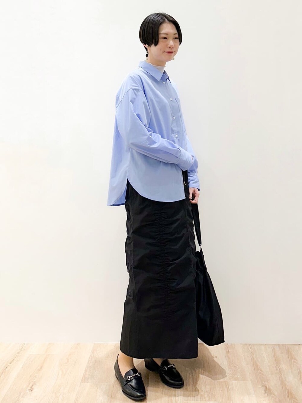 ブルー系のシャツ/ブラウス、ブルー系のTシャツ/カットソー、ブラック系のスカートを着用したレディースの春コーディネートの2枚目の写真