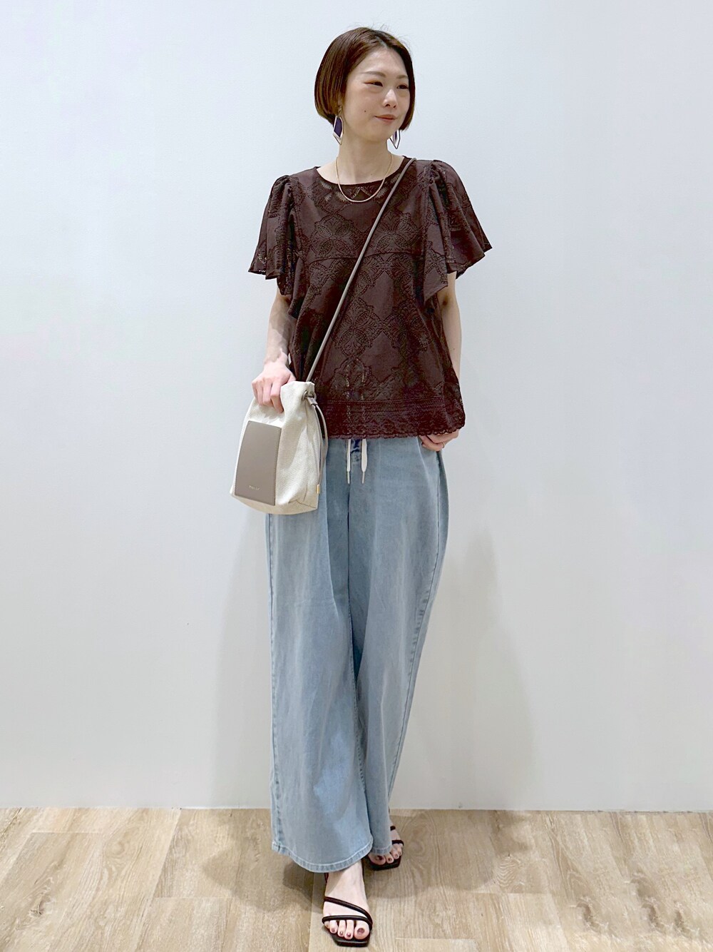 ブラウン系のシャツ/ブラウス、ブルー系のデニムパンツ、ブラック系のサンダルを着用したレディースの春コーディネートの2枚目の写真