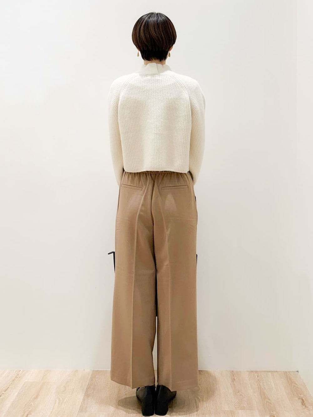 ホワイト系のニット/セーター、イエロー系のその他パンツ、ブラック系のトートバッグを着用したレディースの冬コーディネートの3枚目の写真
