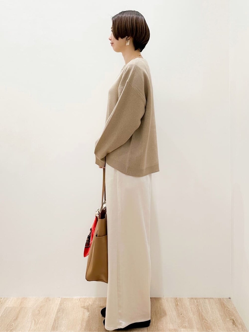 ベージュ系のニット/セーター、ホワイト系のその他パンツ、ベージュ系のトートバッグを着用したレディースの冬コーディネートの3枚目の写真