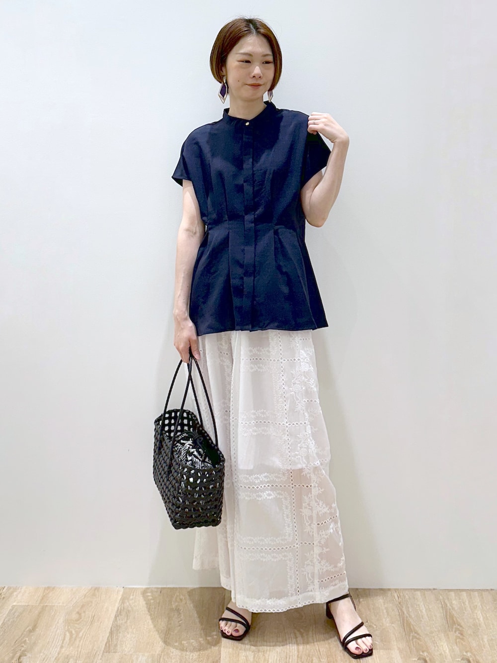 ブルー系のシャツ/ブラウス、ホワイト系のその他パンツ、ブラック系のトートバッグを着用したレディースの春コーディネートの5枚目の写真